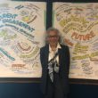 Dr. Elizabeth George in front of drawings of student engagement